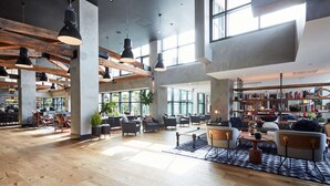 A spacious lobby with wooden floors, modern furniture, and large windows allowing natural light. - Hotel Kabuki, part of JdV by Hyatt (San Francisco)