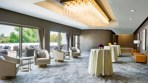 A spacious room with a large window, a chandelier, and a carpeted floor. - Delta Hotels by Marriott Ontario Airport (Ontario)