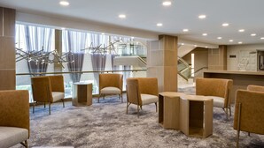 A hotel lobby with seating areas, a staircase, and a reception desk. - Delta Hotels by Marriott Ontario Airport (Ontario)