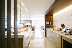 Una cocina moderna con una encimera larga, electrodomésticos de acero inoxidable y un revestimiento de pared capitonado.