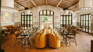 Un comedor amplio con techos altos, ventanas grandes y una disposición central de los asientos.