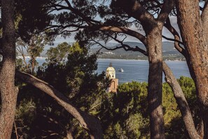 Uitzicht op de kust met een toren en bomen.