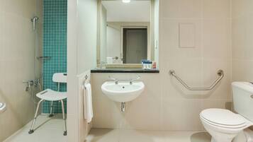 Une salle de bain équipée d’un lavabo, de toilettes et d’un espace douche.