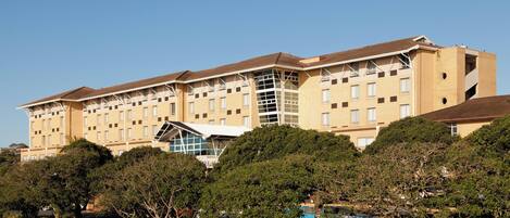 A multi-story hotel with a modern architectural design, featuring a prominent glass facade and a flat roof.
