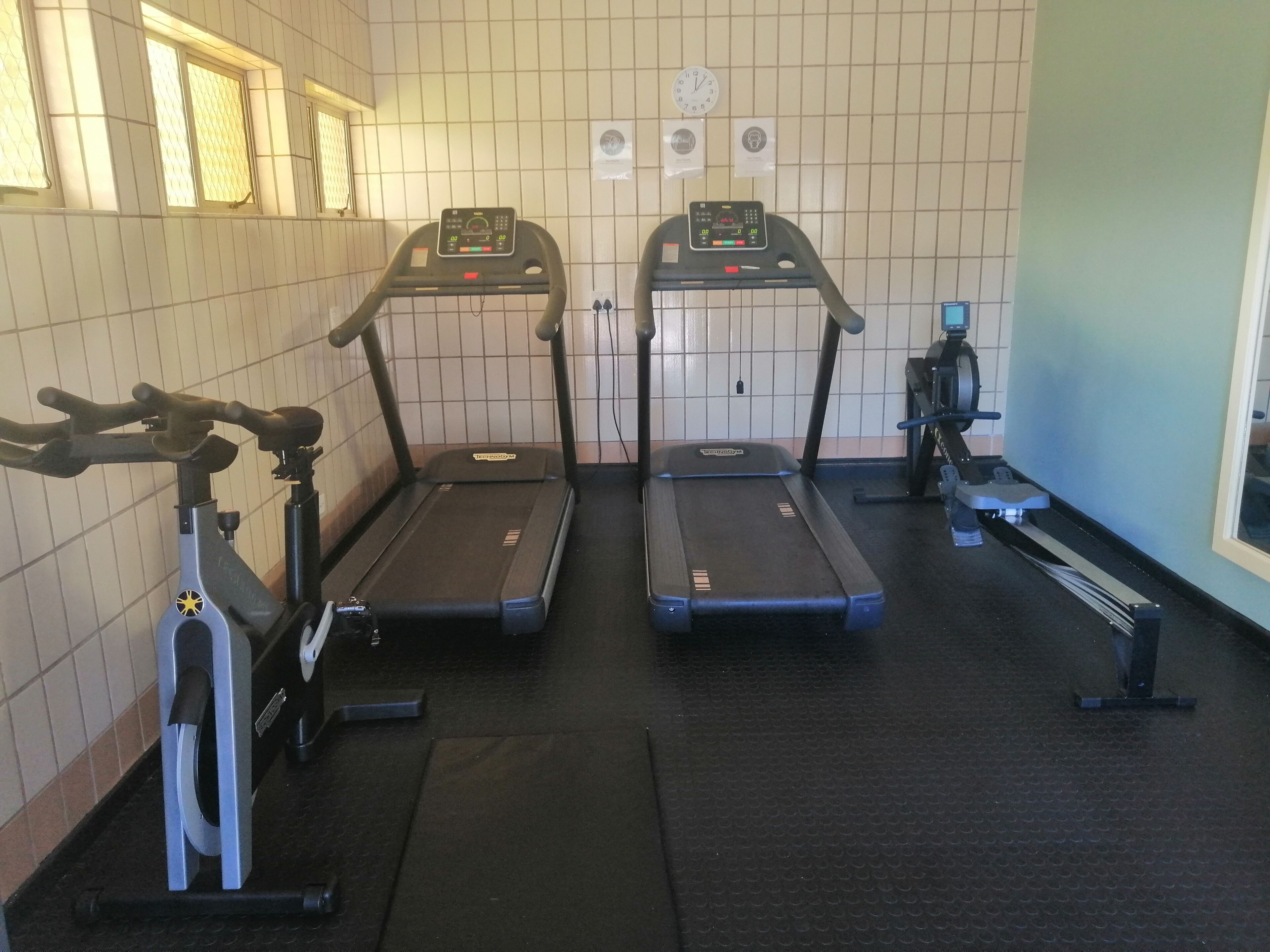 A gym with two treadmills, a stationary bike, and a rowing machine.