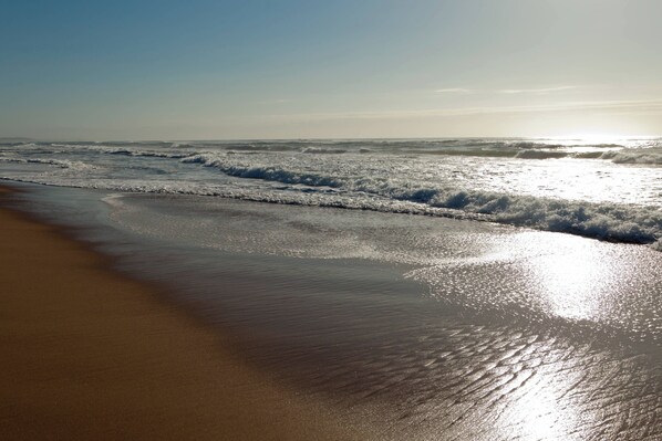 Guests can enjoy a serene beach experience with gentle waves lapping onto the shore.
