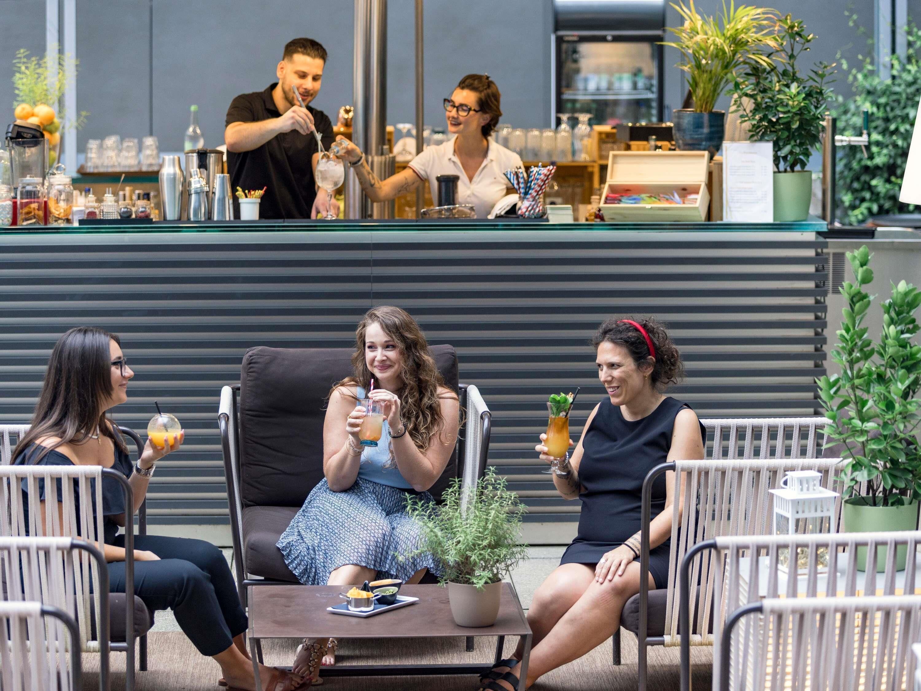 A bar area with a counter, bar tools, and a seating area with chairs and a table.