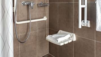 Un espace douche équipé d’un pommeau de douche à main et d’un porte-serviettes blanc.