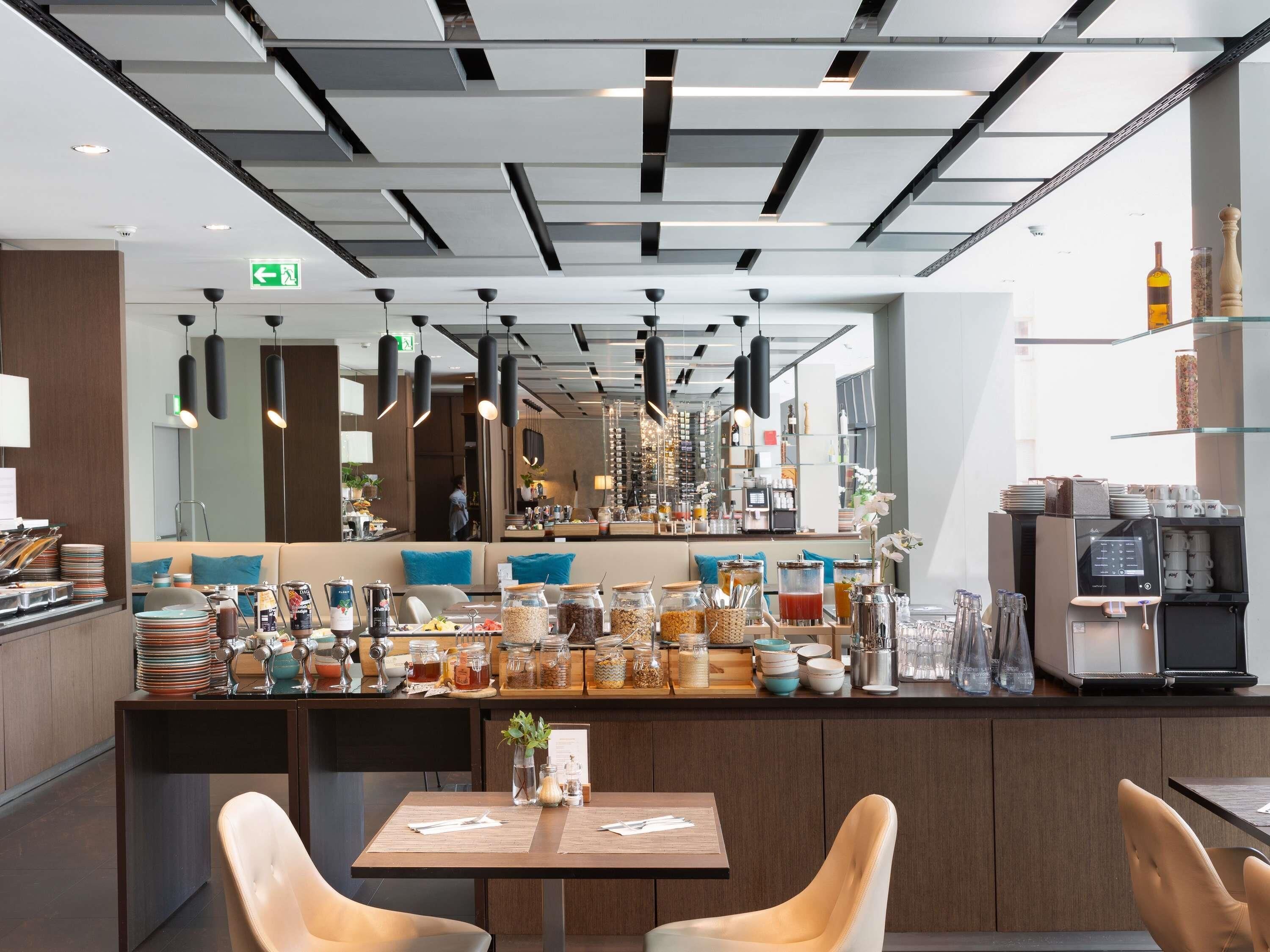 Una zona de bar moderna con una barra que exhibe diferentes alimentos y una máquina de café.