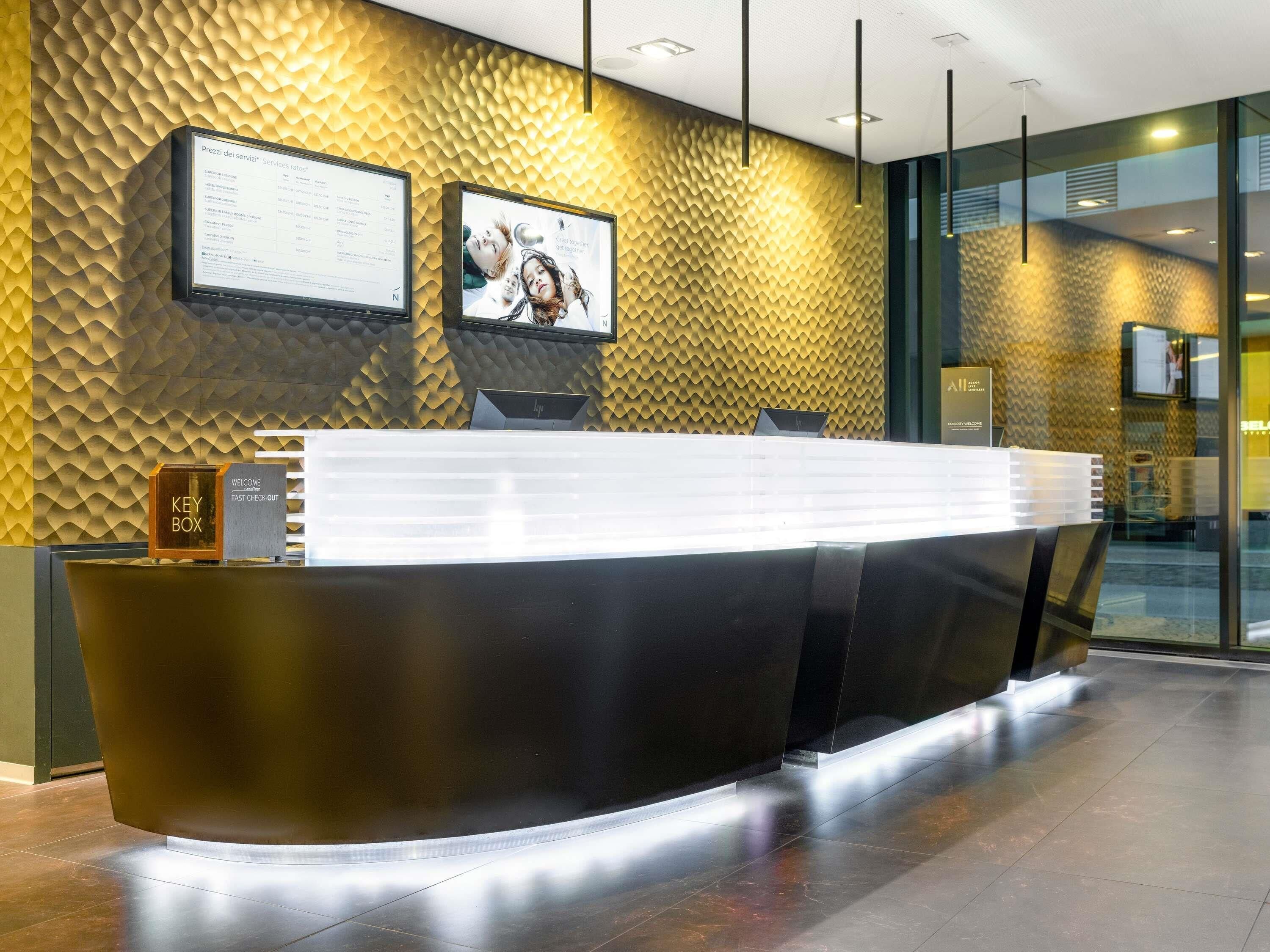 A reception desk with a digital display, a key box, and a welcome sign.