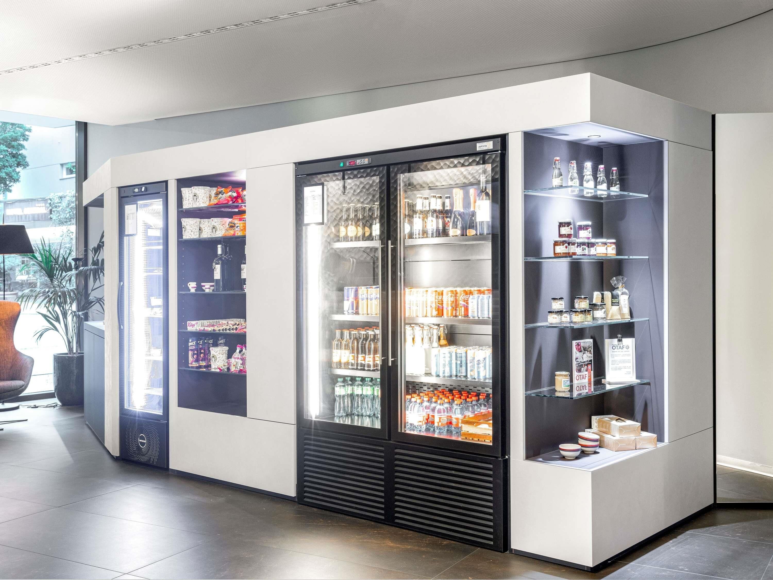 Una moderna edicola con distributori refrigerati, scaffali pieni di bevande e un design pulito e minimalista.