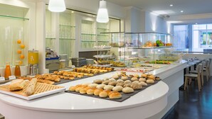 A buffet with various food items and a glass display case. - NH Brussels Grand Place Arenberg (Brussels)