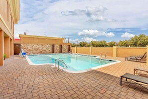 Una piscina al aire libre de temporada, sombrillas