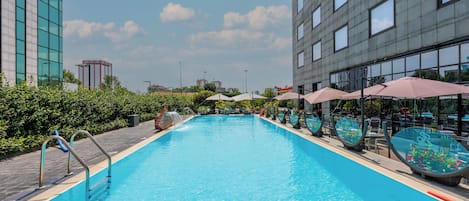 Una piscina al aire libre de temporada, sillones reclinables de piscina