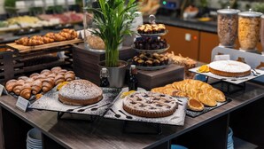 A buffet with various pastries and desserts, including croissants, cakes, and a variety of other baked goods.