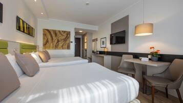 Una habitación de hotel con cama, escritorio, silla y televisor.
