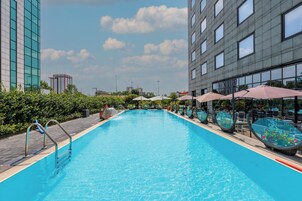 Een seizoensgebonden buitenzwembad, ligstoelen bij het zwembad