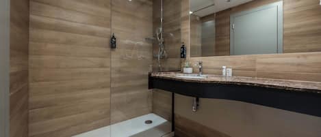 A modern bathroom with a shower, a sink, and a mirror.