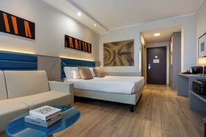 A modern hotel room with a bed, a sofa, a coffee table with books, and artwork on the walls. - iH Hotels Milano Lorenteggio (Milan)