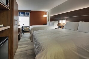 Hotellihuone, jossa on kaksi sänkyä, työpöytä, tuoli ja ikkuna.