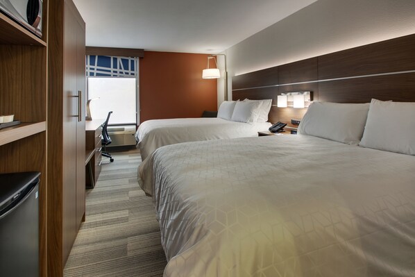 A hotel room with two beds, a desk with a chair, a lamp, and a view of the outdoors. - Holiday Inn Express Voorhees - Mt. Laurel  by IHG (Voorhees)