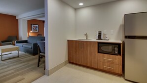 A compact kitchen with a microwave, coffee maker, and refrigerator.