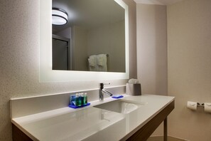 A modern bathroom with a large mirror, a sink, and a towel rack. - Holiday Inn Express Voorhees - Mt. Laurel  by IHG (Voorhees)