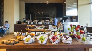 Une table de buffet proposant divers plats et fruits.