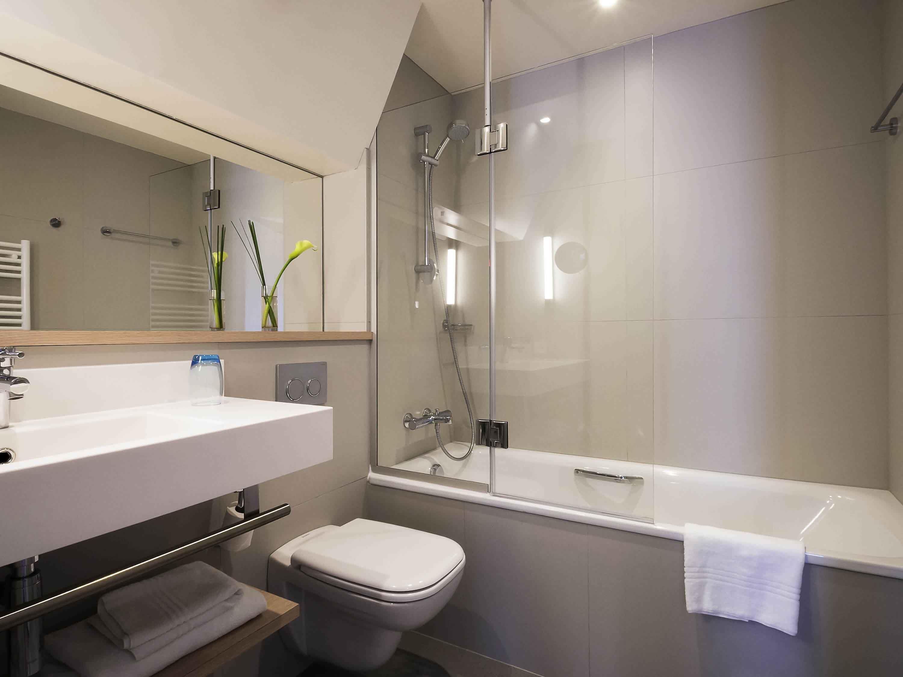 Une salle de bain moderne avec une douche à parois de verre, un lavabo blanc et des toilettes.