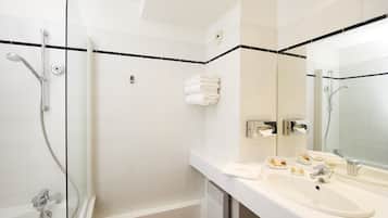 Ein modernes Badezimmer mit Waschbecken, Spiegel und Duschbereich.