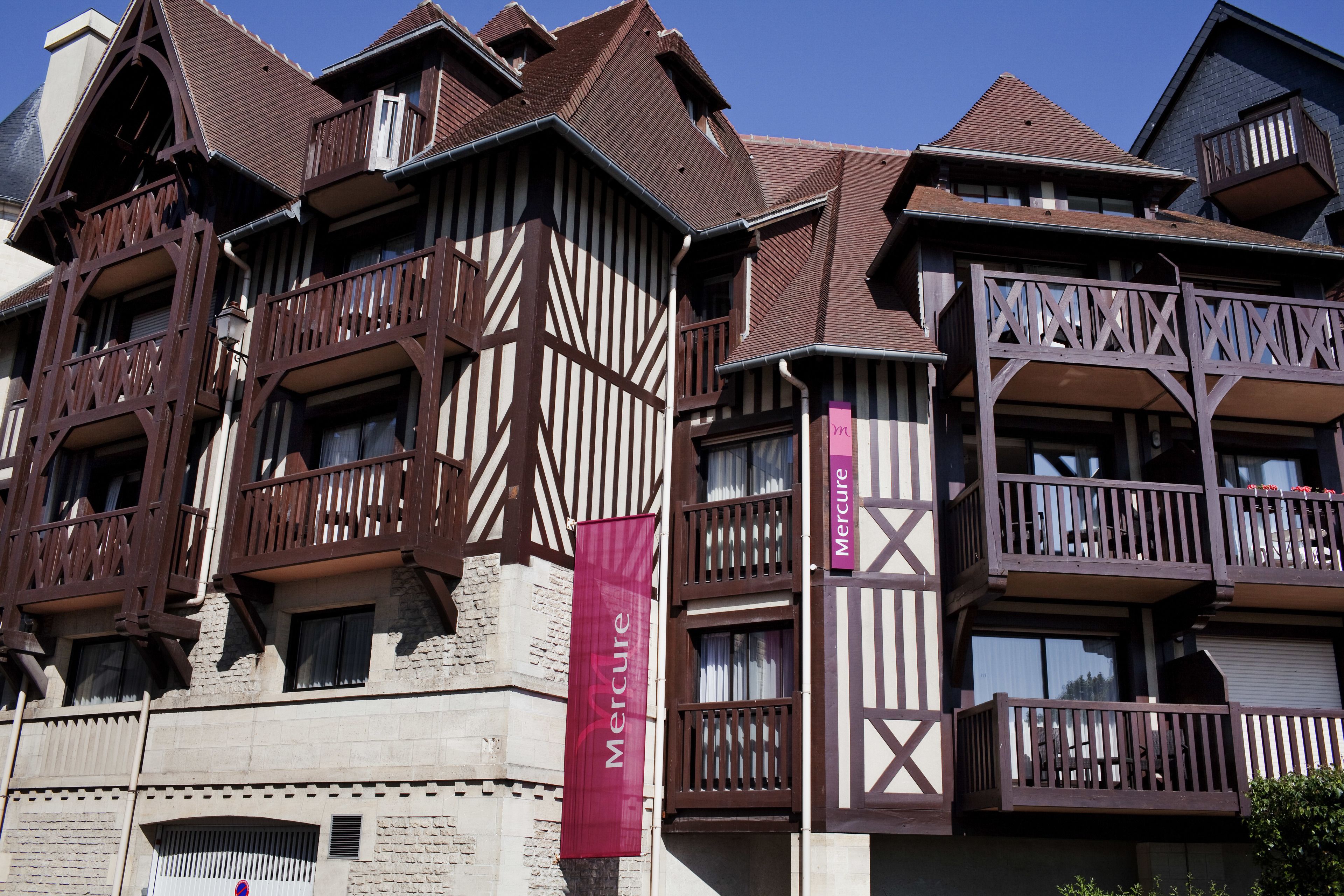 A traditional half-timbered building with multiple balconies and a prominent 'Mercure' banner.