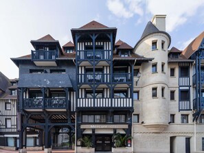 A hotel with a traditional European architectural style, featuring multiple balconies, a prominent tower, and a sign indicating it is the Mercure Hotel.