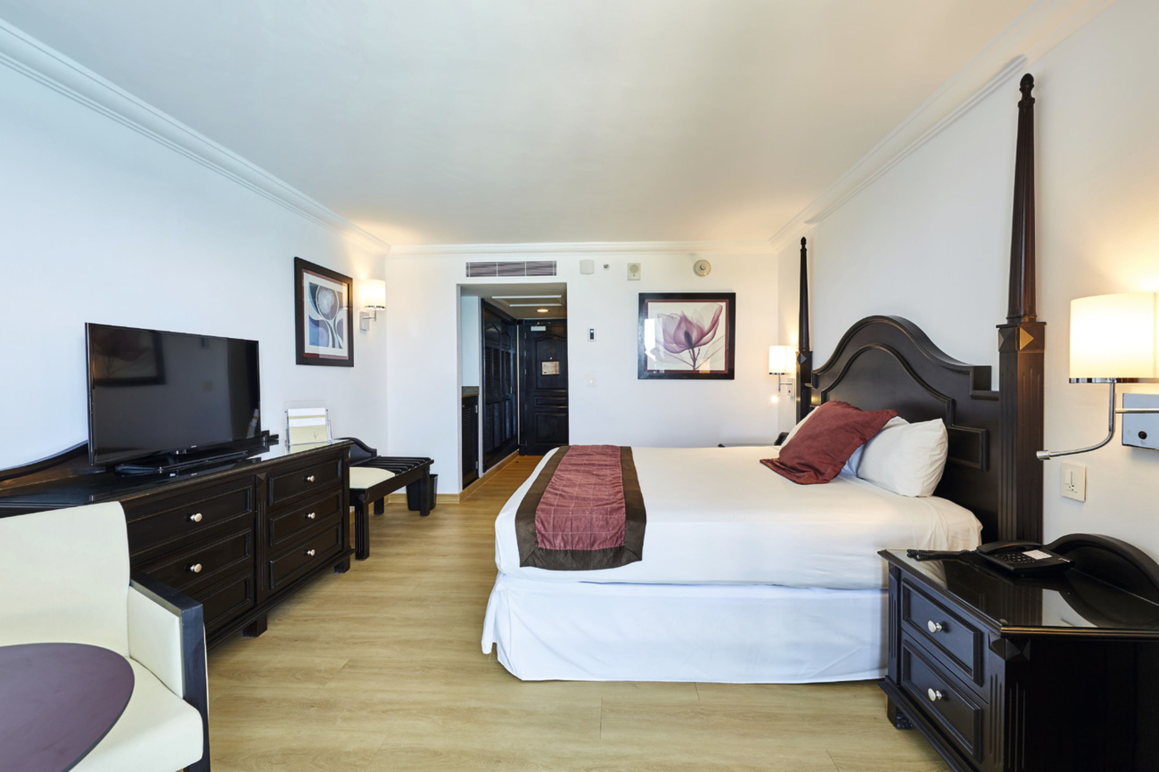 Una camera d'albergo con un letto, una televisione, una scrivania e una sedia.