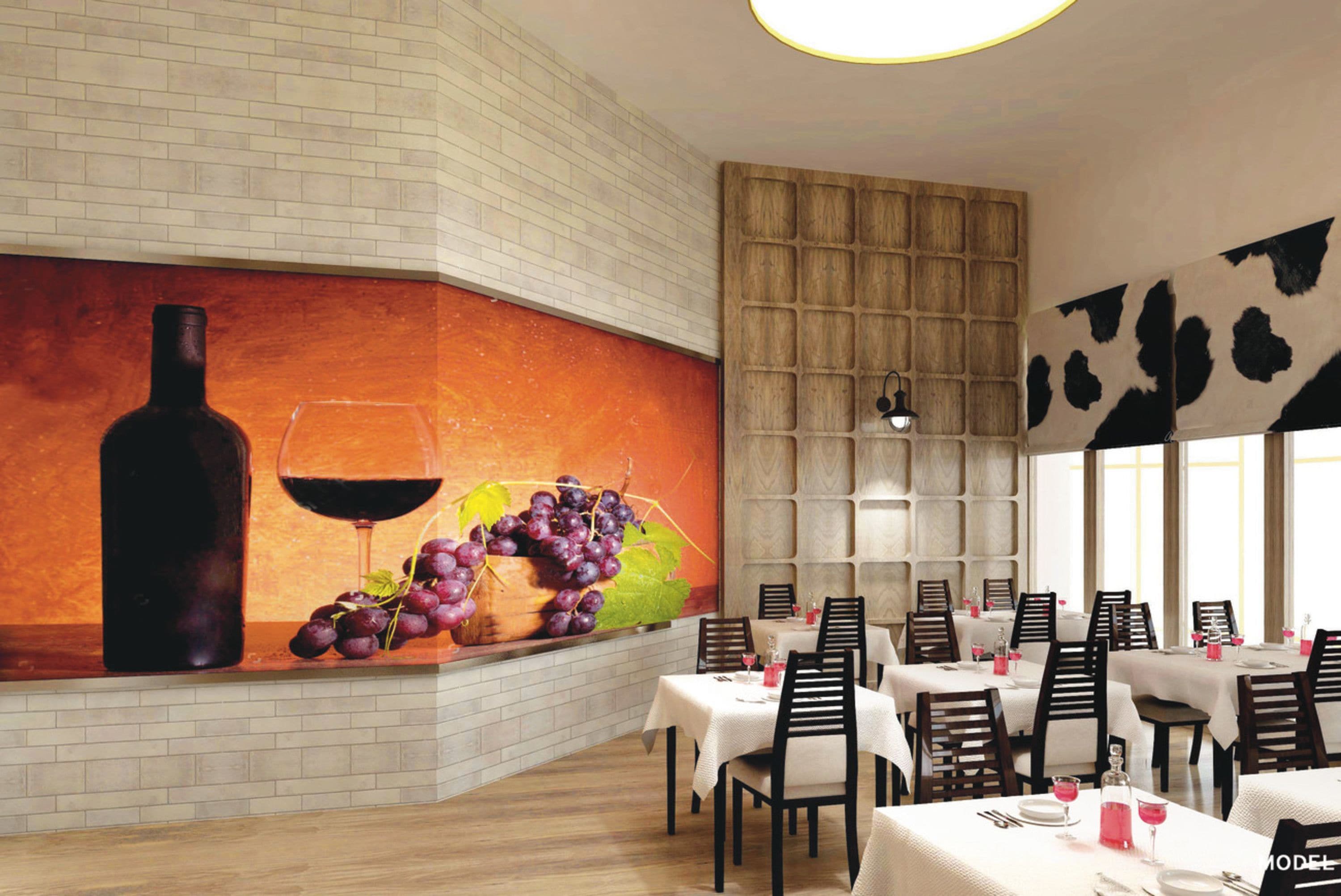 A restaurant with a mural of a wine bottle and grapes, tables set with white tablecloths, and a cow pattern on the wall.