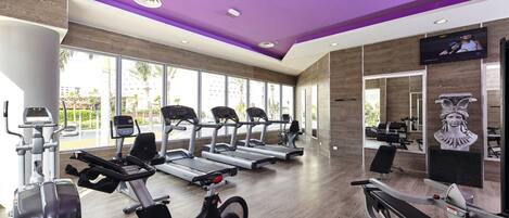 A gym with treadmills, stationary bikes, and elliptical machines.