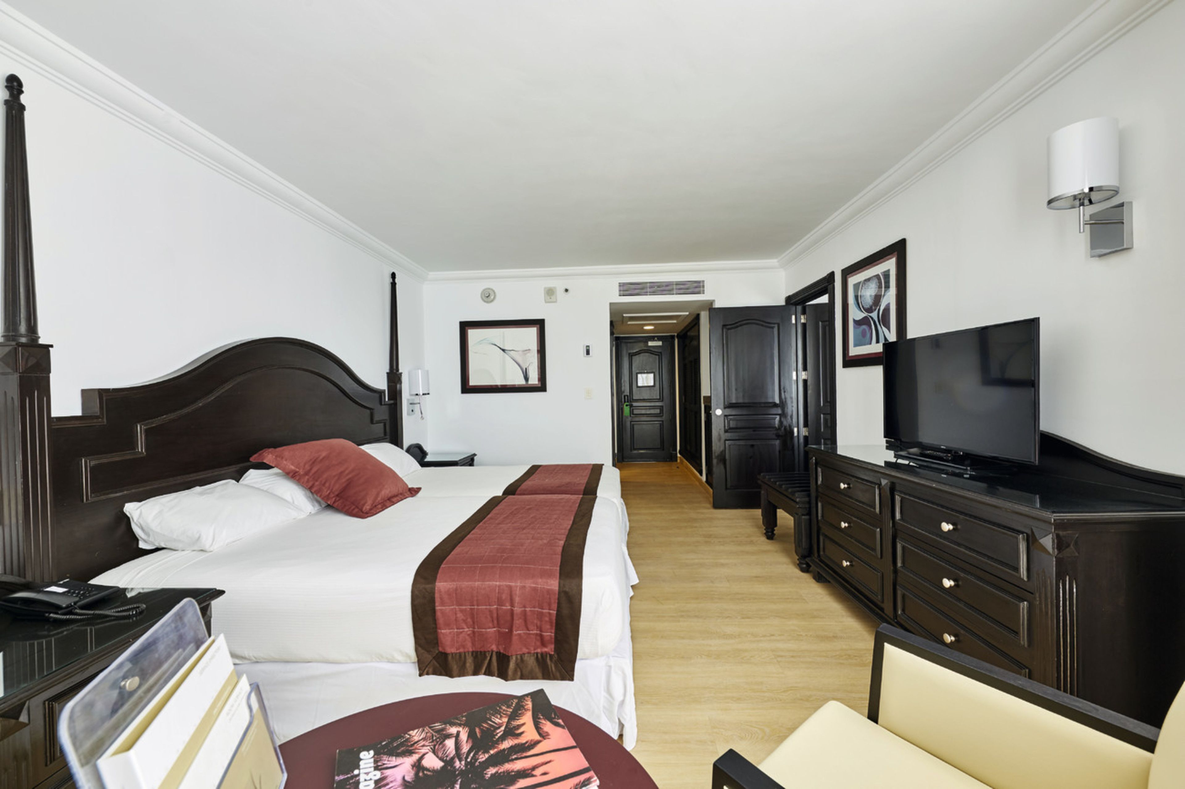 Une chambre d’hôtel avec un grand lit, une télévision, un bureau et une armoire.