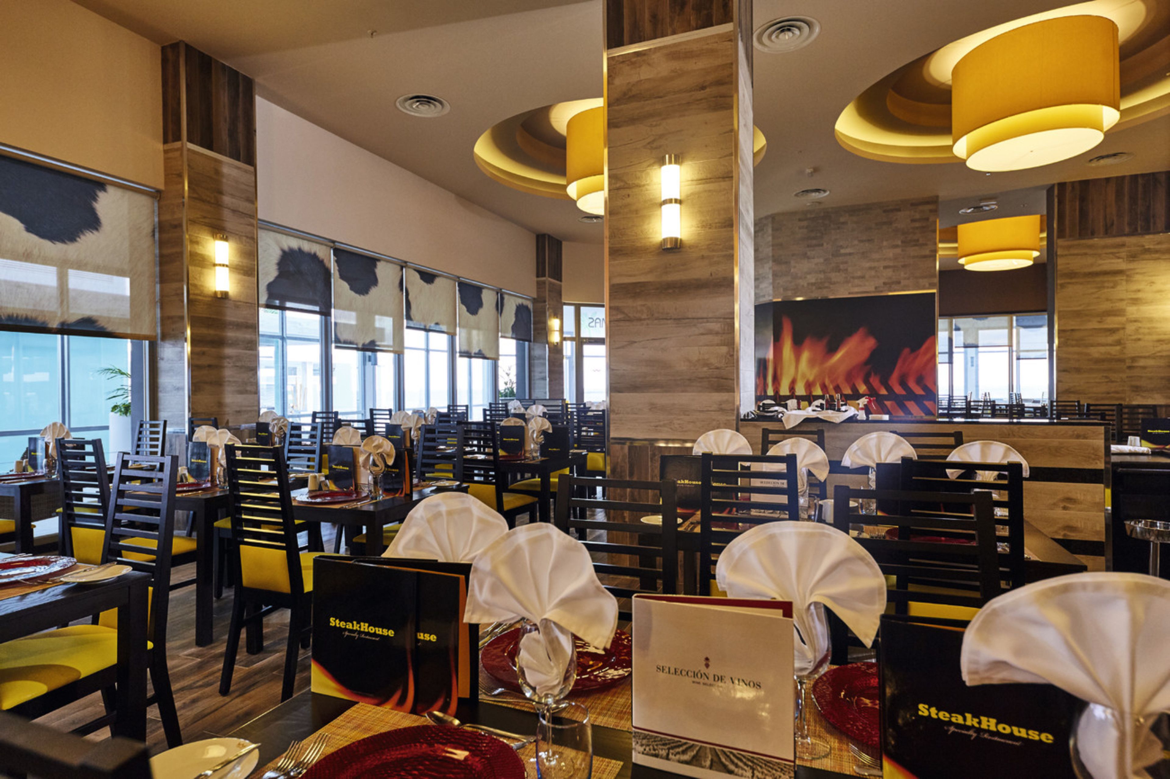 Interno di un ristorante con diversi tavoli, sedie e un espositore per i menu.