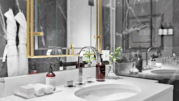 Une salle de bain moderne avec un grand miroir, un lavabo et des articles de toilette.