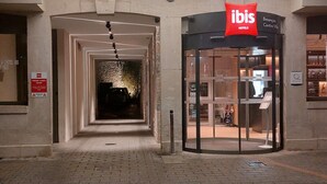 An entrance to an ibis hotel with a glass door and a sign above it. - ibis Besancon Centre Ville (Besancon)