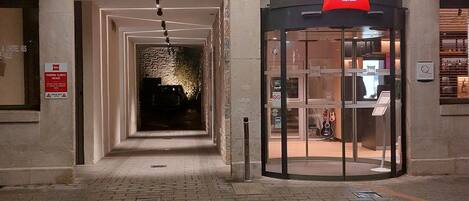 An entrance to an ibis hotel with a glass door and a sign above it.