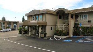 A multi-story building with a parking lot in front. - Budget Inn of Hayward (Hayward)
