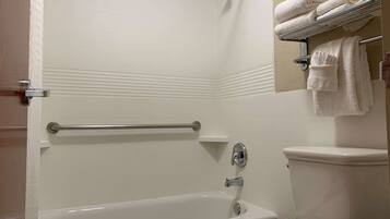 A bathroom with a bathtub, toilet, and towel rack.