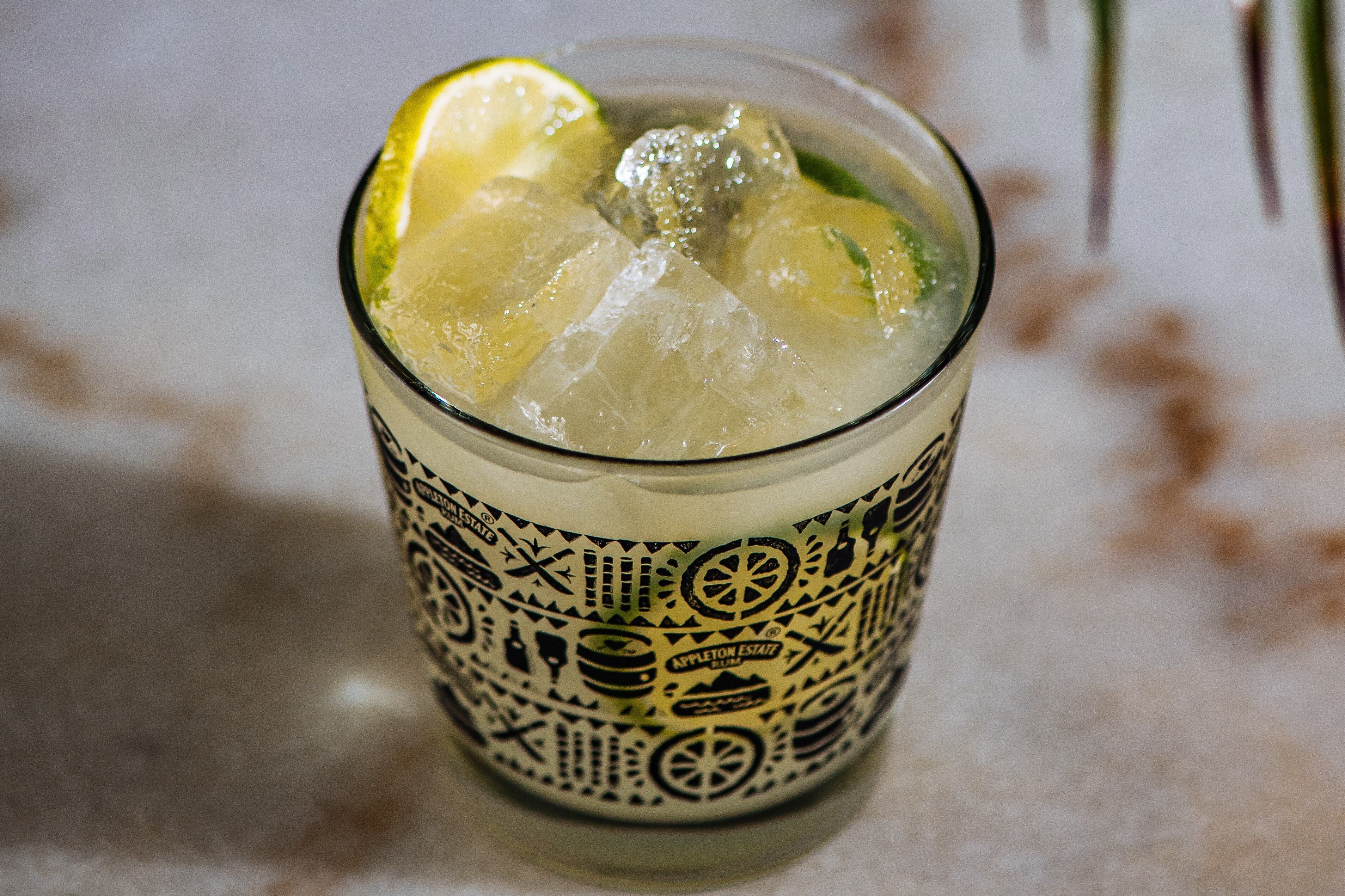 Un verre contenant de la glace et des rondelles de citron vert, et peut-être une boisson.