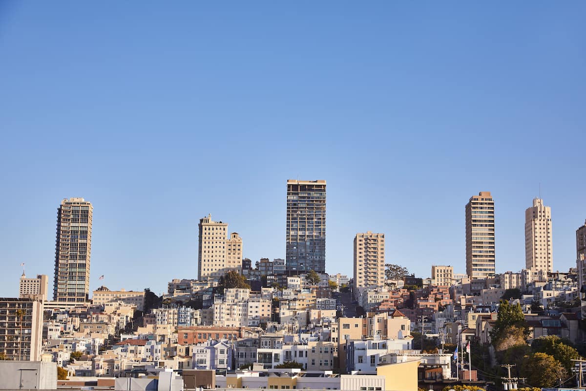 A cityscape with multiple high-rise buildings and a densely packed residential area.