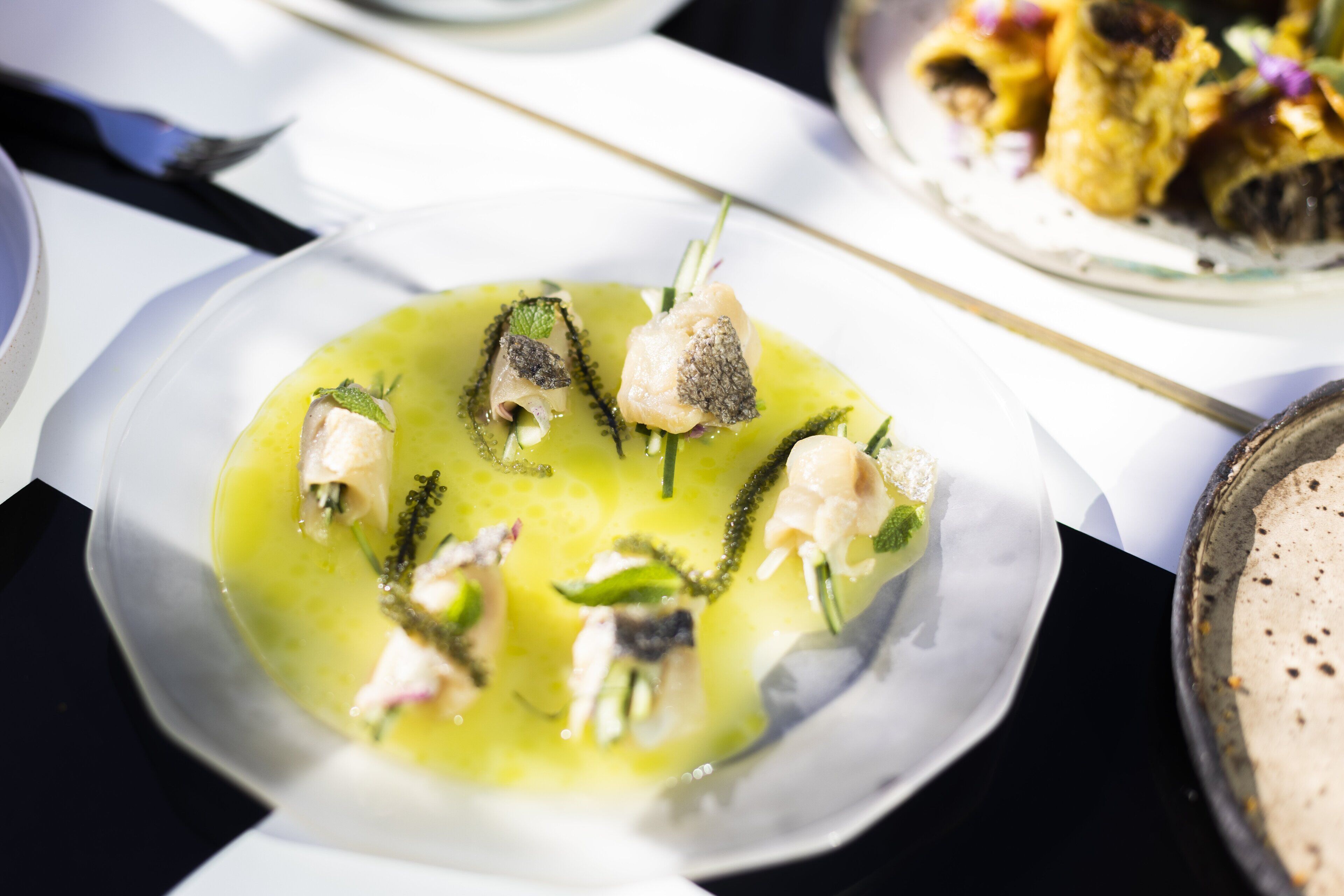A plate of food with various seafood items and green garnish.
