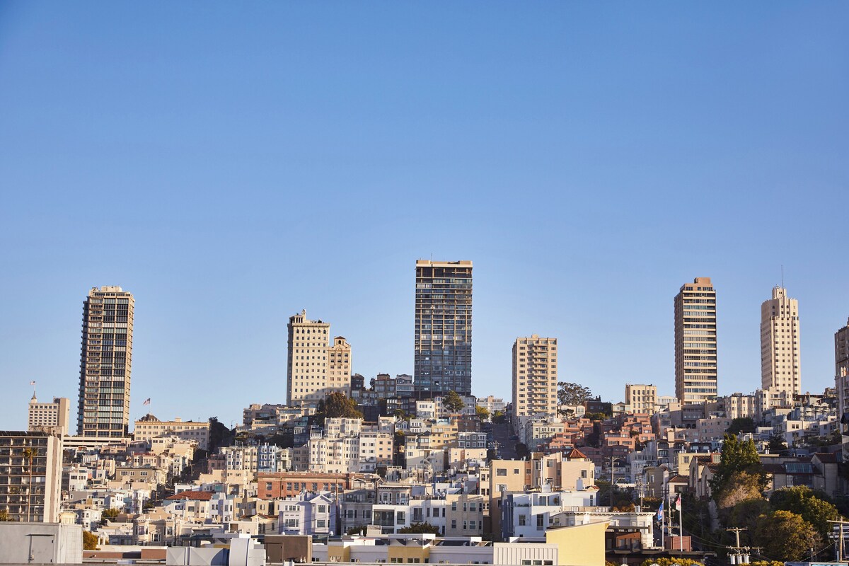 A cityscape with multiple high-rise buildings and a densely packed residential area.