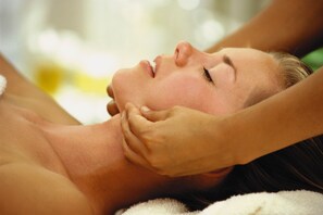 Une personne allongée, le bas du corps couvert d’une serviette, ce qui évoque un spa ou un lieu de détente.