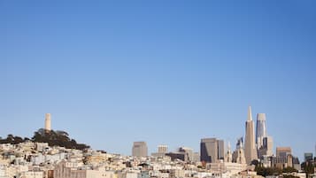 A cityscape with a prominent tower on a hill, a variety of buildings, and a clear blue sky.