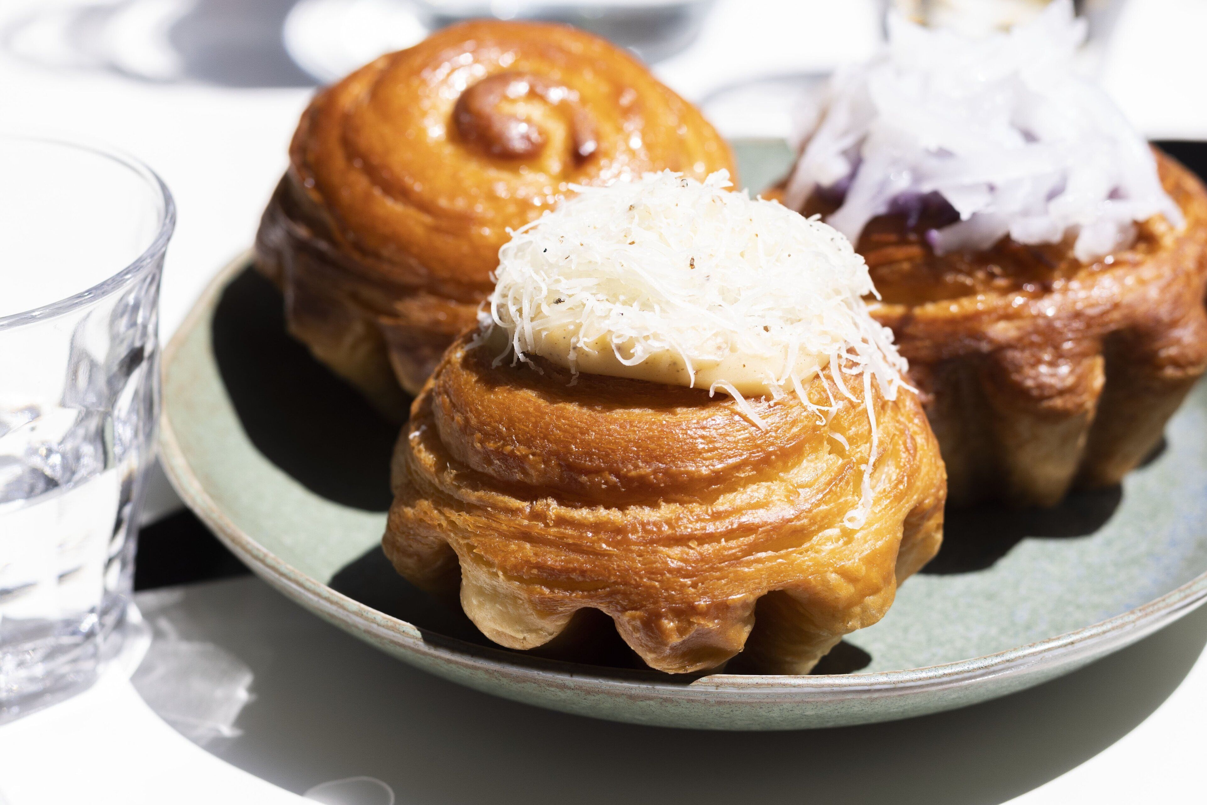 A plate with pastries, a glass of water, and a bowl.