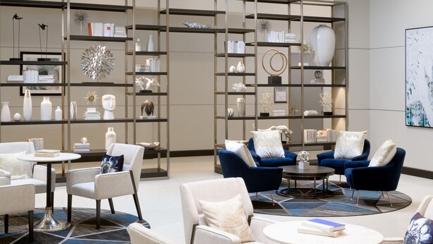 A spacious lobby with a high ceiling, modern furniture, and a large display of decorative items.